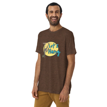A man standing wearing a brown tee shirt with a printed graphic of a monkey hanging on a branch with the words, Let's Hang. Designed by Wizard Prints
