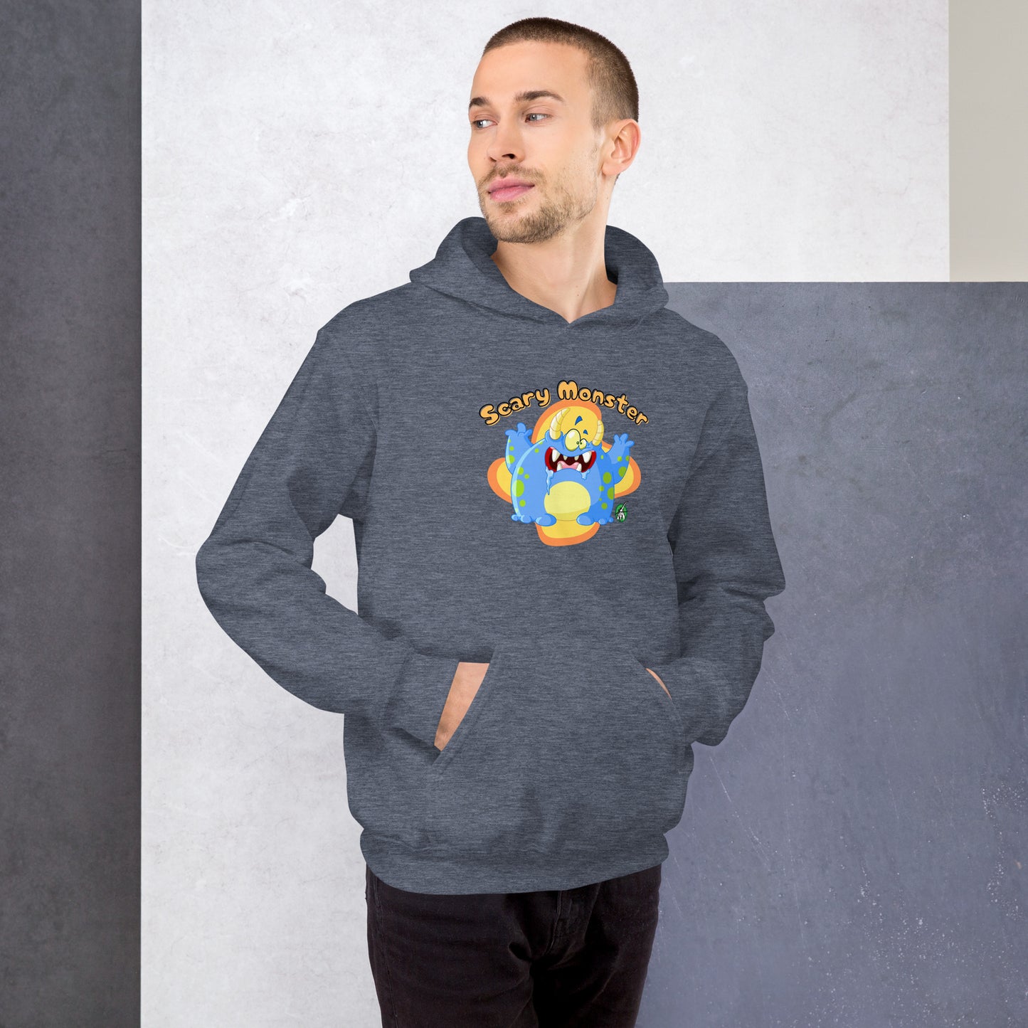 A man standing wearing a dark grey hoodie with a printed graphic of a cartoon monster and the words, Scary Monster. Designed by Wizard Prints.