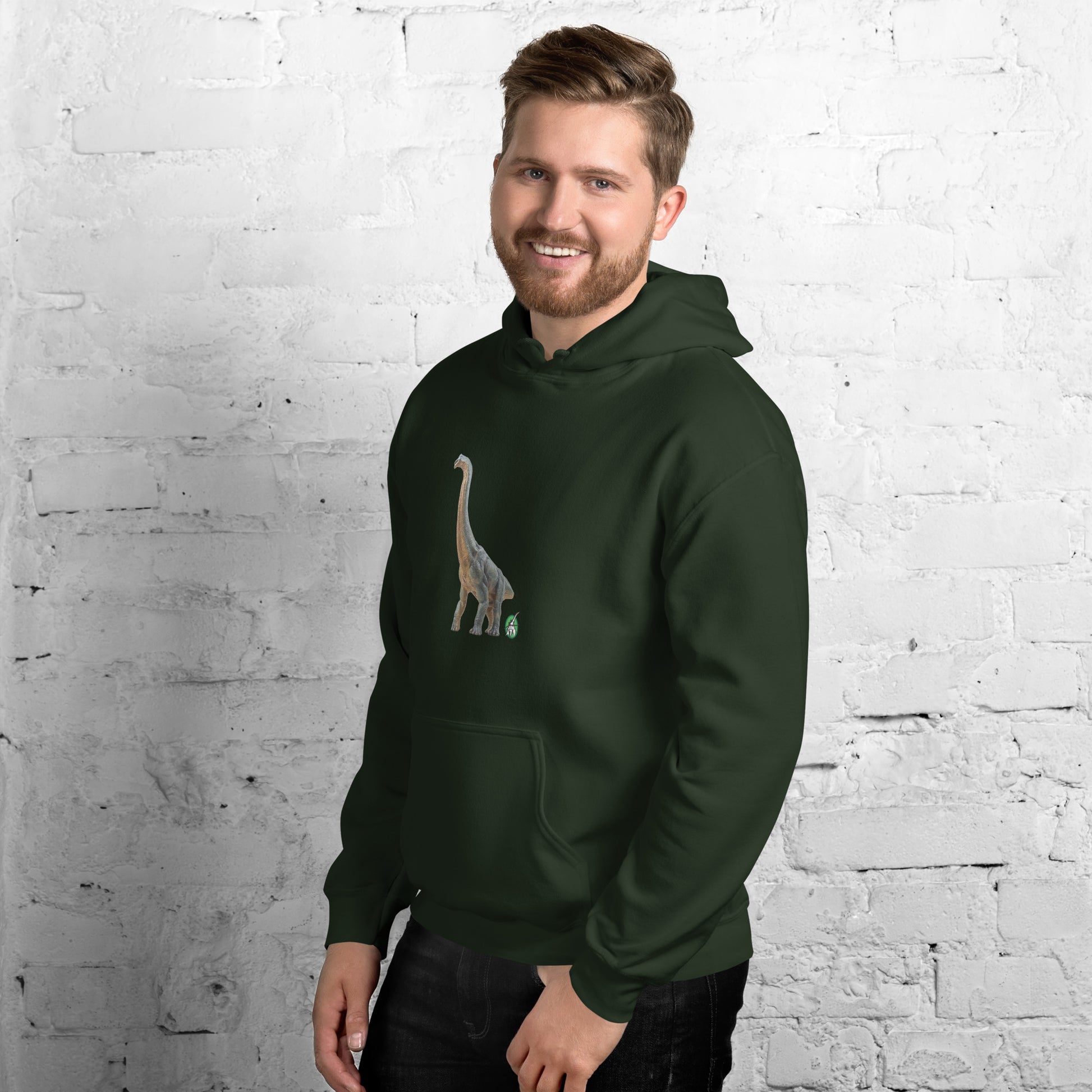 A man standing wearing a forest green hoodie with a printed graphic of a life like dinosaur, designed by Wizard Prints