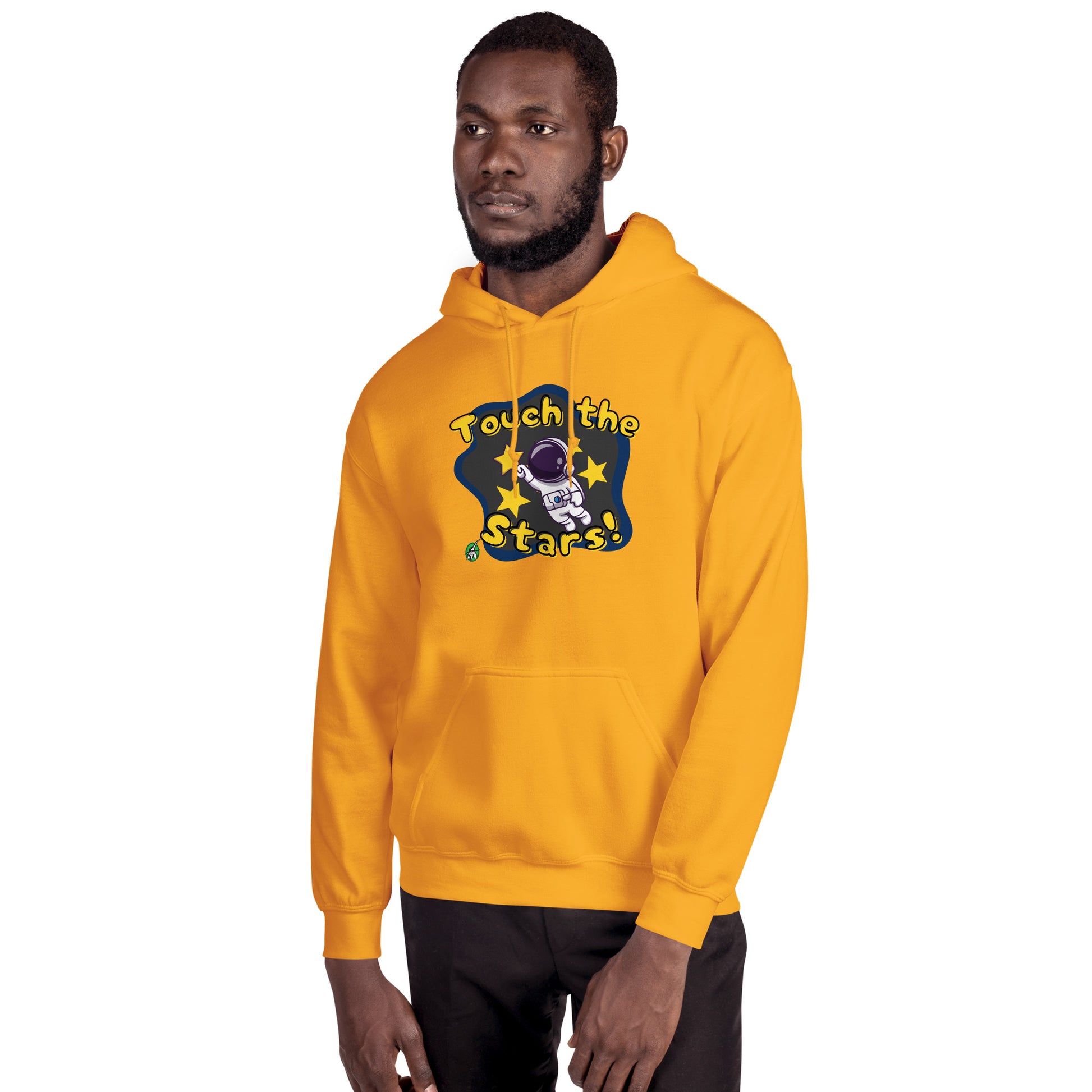A man standing wearing a gold hoodie with a printed graphic of a cartoon astronaut and the words, Touch the Stars. Designed by Wizard Prints.