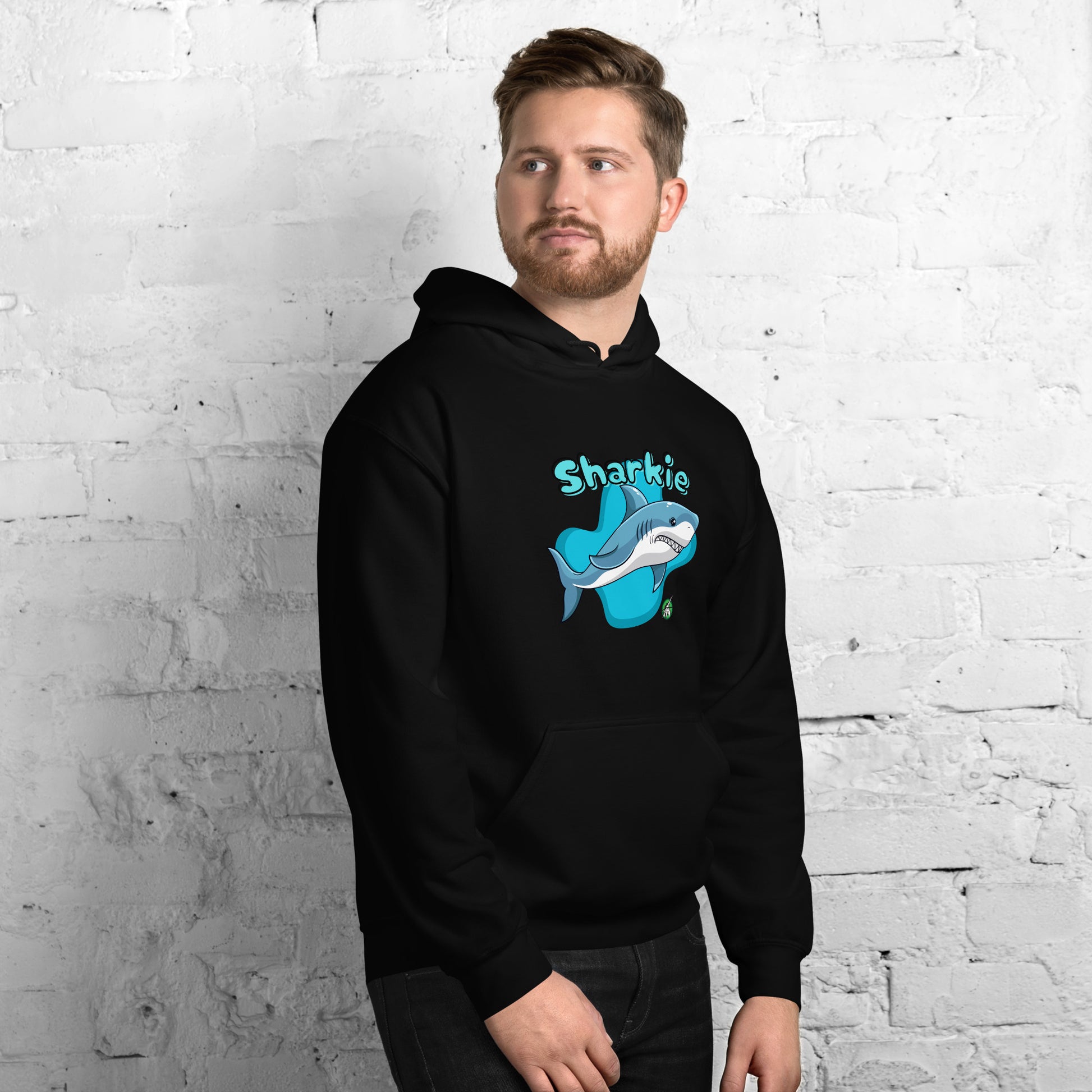 A man standing wearing a black hoodie with a printed graphic of a cartoon shark and the word, Sharkie. Designed by Wizard Prints.