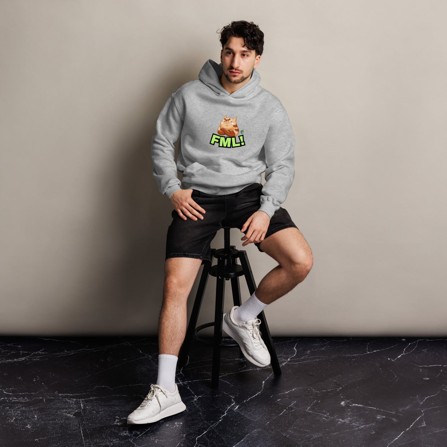 A man sitting wearing a grey hoodie by Wizard Prints featuring a printed graphic of a grumpy cat with the words, 'FML!'. 