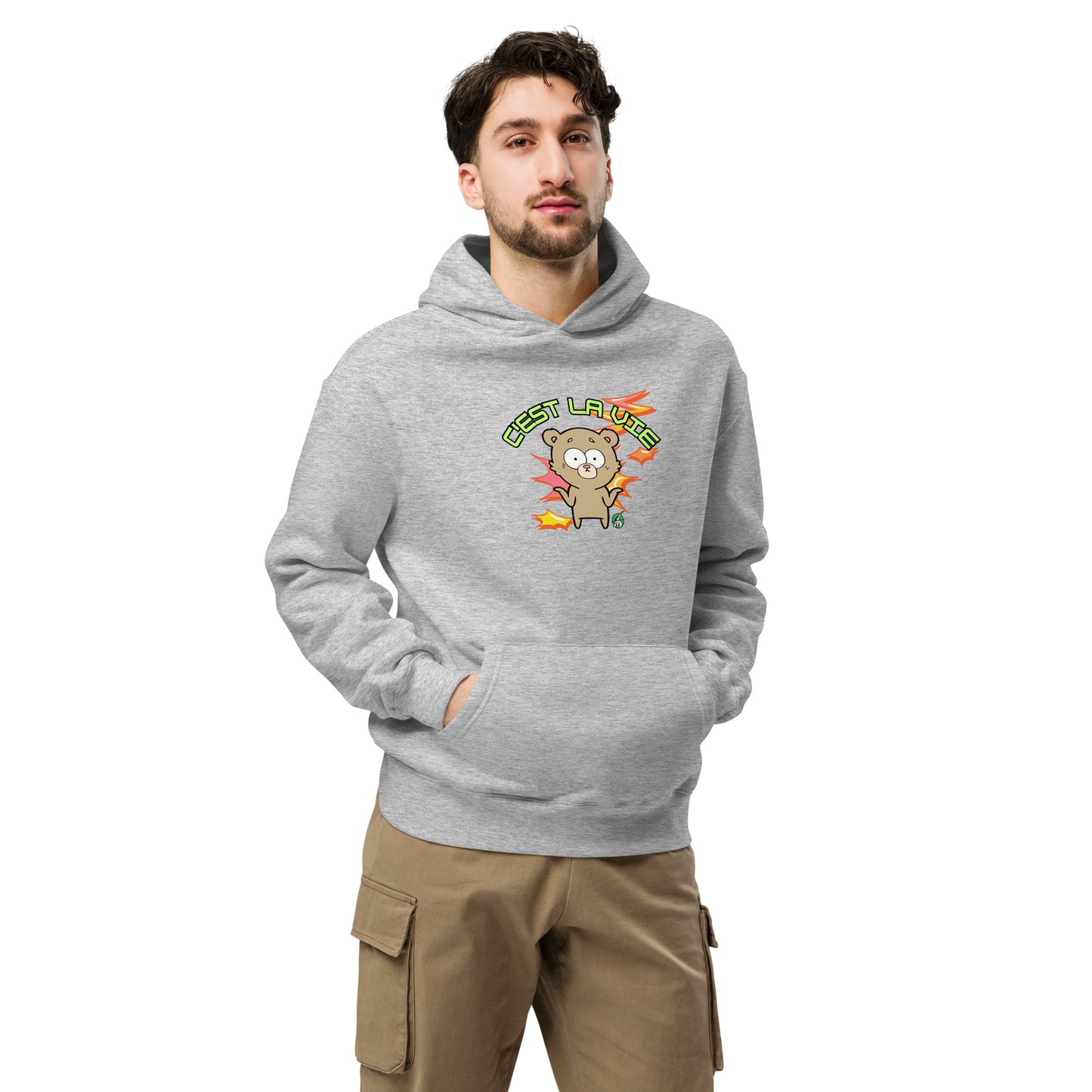 A man standing wearing a grey hoodie by Wizard Prints featuring a printed graphic of a shrugging cartoon bear and the words, C'est La Vie.
