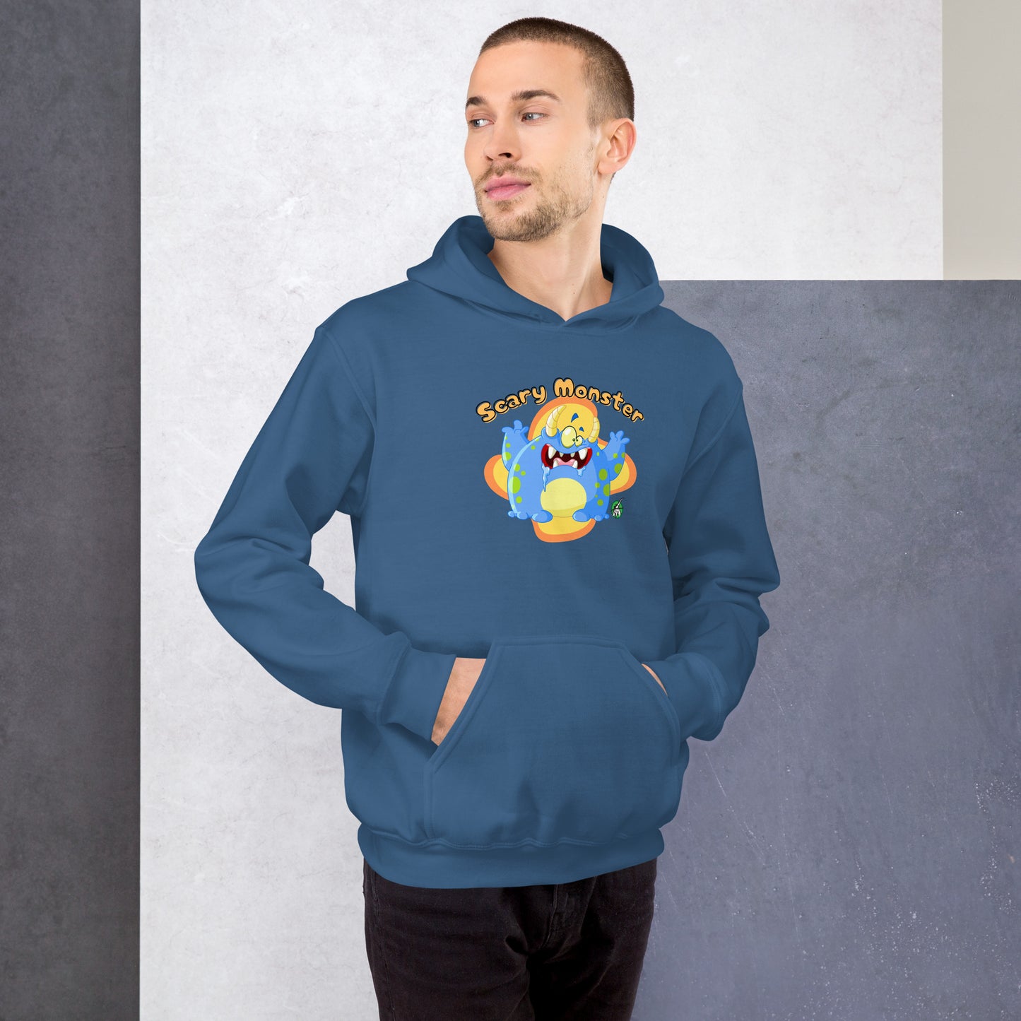 A man standing wearing an indigo hoodie with a printed graphic of a cartoon monster and the words, Scary Monster. Designed by Wizard Prints.