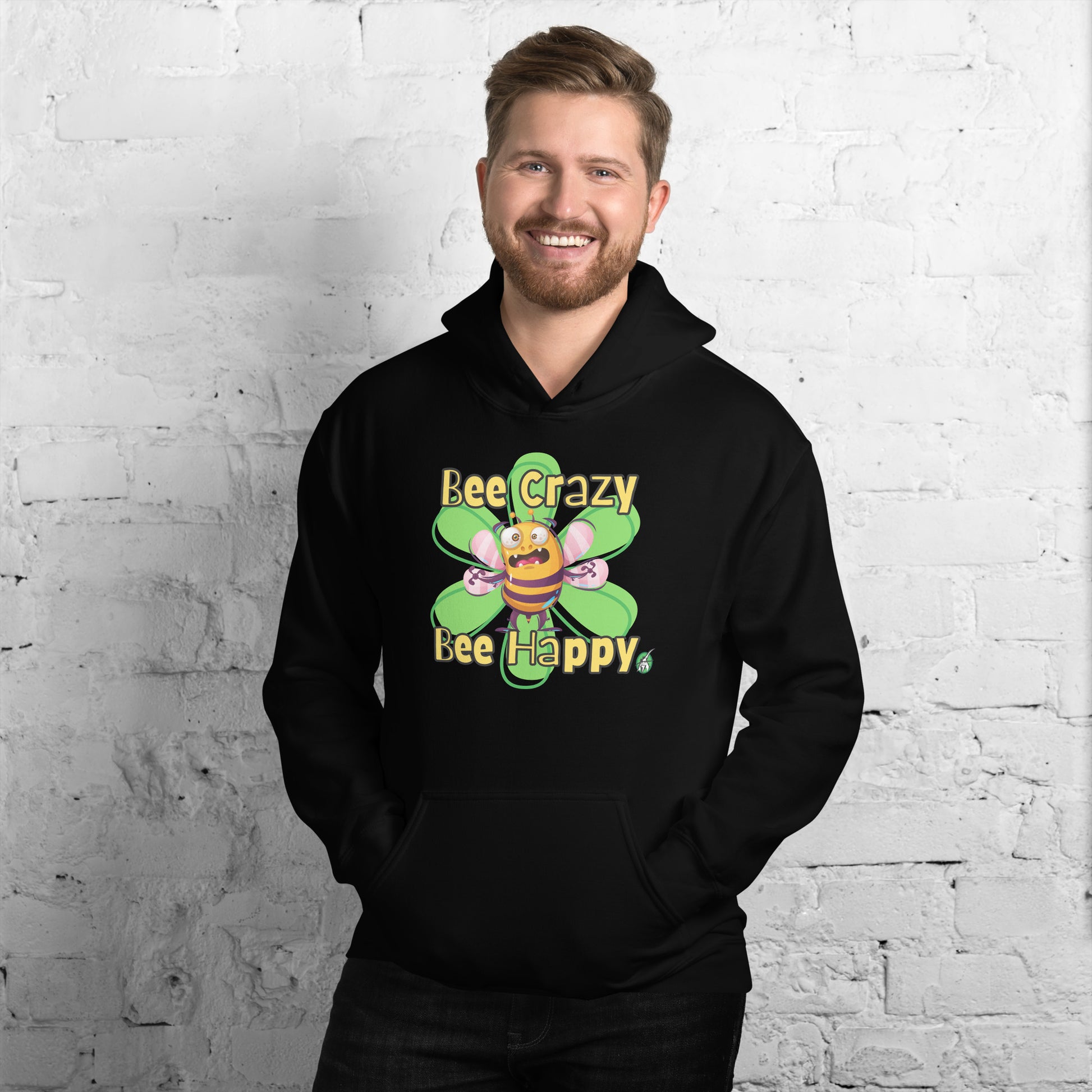 A man standing wearing a black hoodie with a printed graphic of a bee with the words, 'Bee Crazy Bee Happy'. Designed by Wizard Prints.