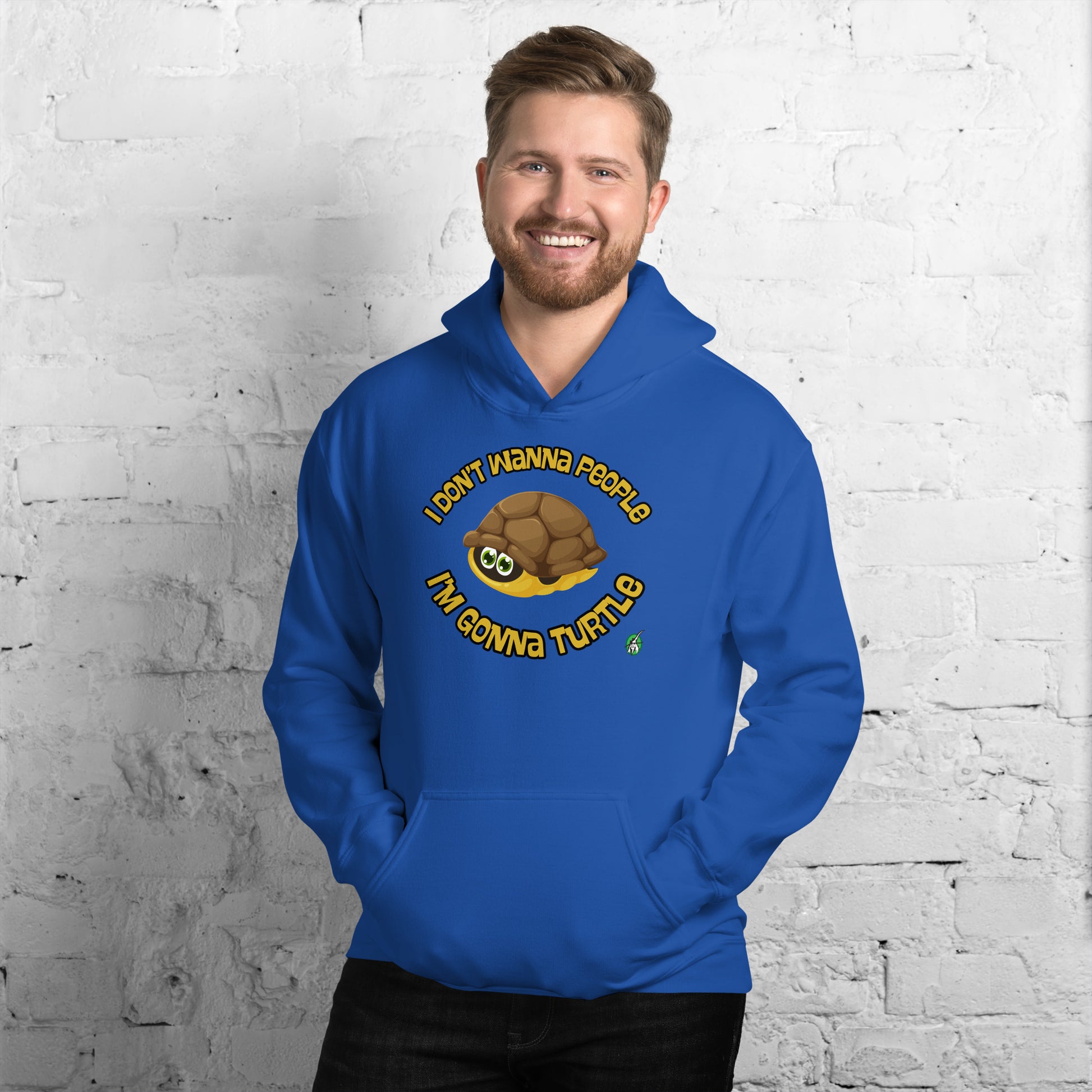 A man standing wearing a blue hoodie with a printed graphic of a turtle with the words, 'I Don't Wanna People, I'm Gonna Turtle'. Designed by Wizard Prints.