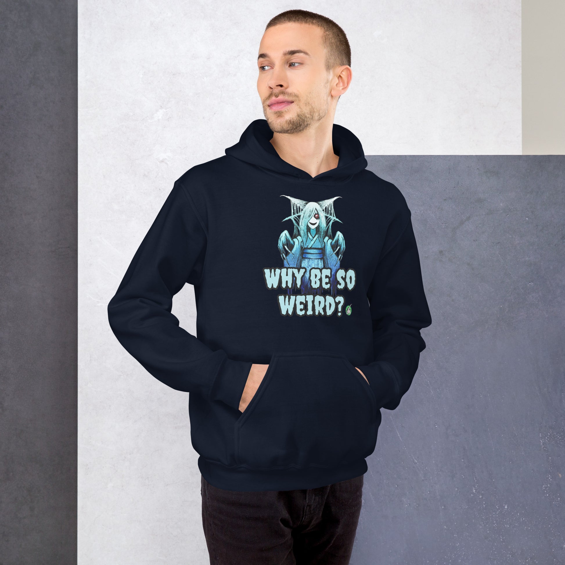 A man standing and wearing a navy hoodie with a printed graphic of a blue ghost girl with the words, 'Why Be So Weird?'. Designed by Wizard Prints.
