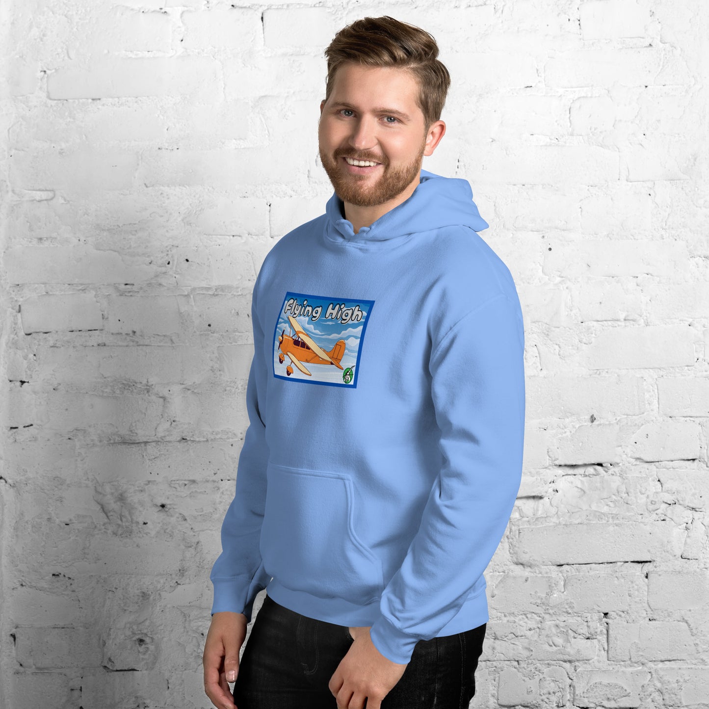 A man standing wearing a light blue hoodie with the printed graphic of a vintage airplane and the words, Flying High, by Wizard Prints.