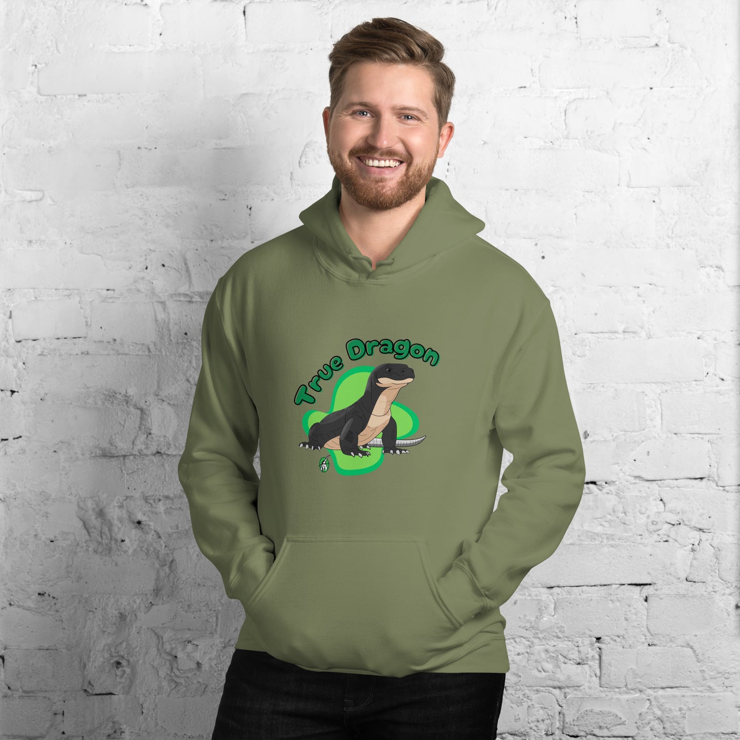 A man standing wearing a military green hoodie with a printed graphic of a komodo dragon and the words, True Dragon. Designed by Wizard Prints.