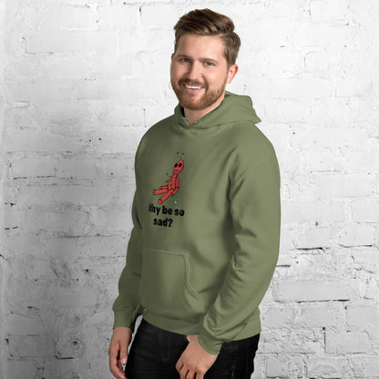 A man standing wearing a military green hoodie with a printed graphic of a voodoo doll and the words, Why be so sad? Designed by Wizard Prints.