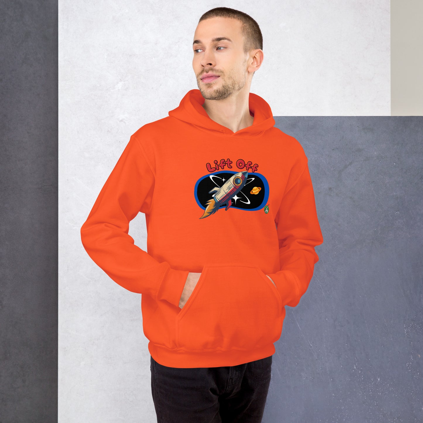 A man standing wearing an orange hoodie with a printed graphic of a rocket and the words, Lift Off. Designed by Wizard Prints.
