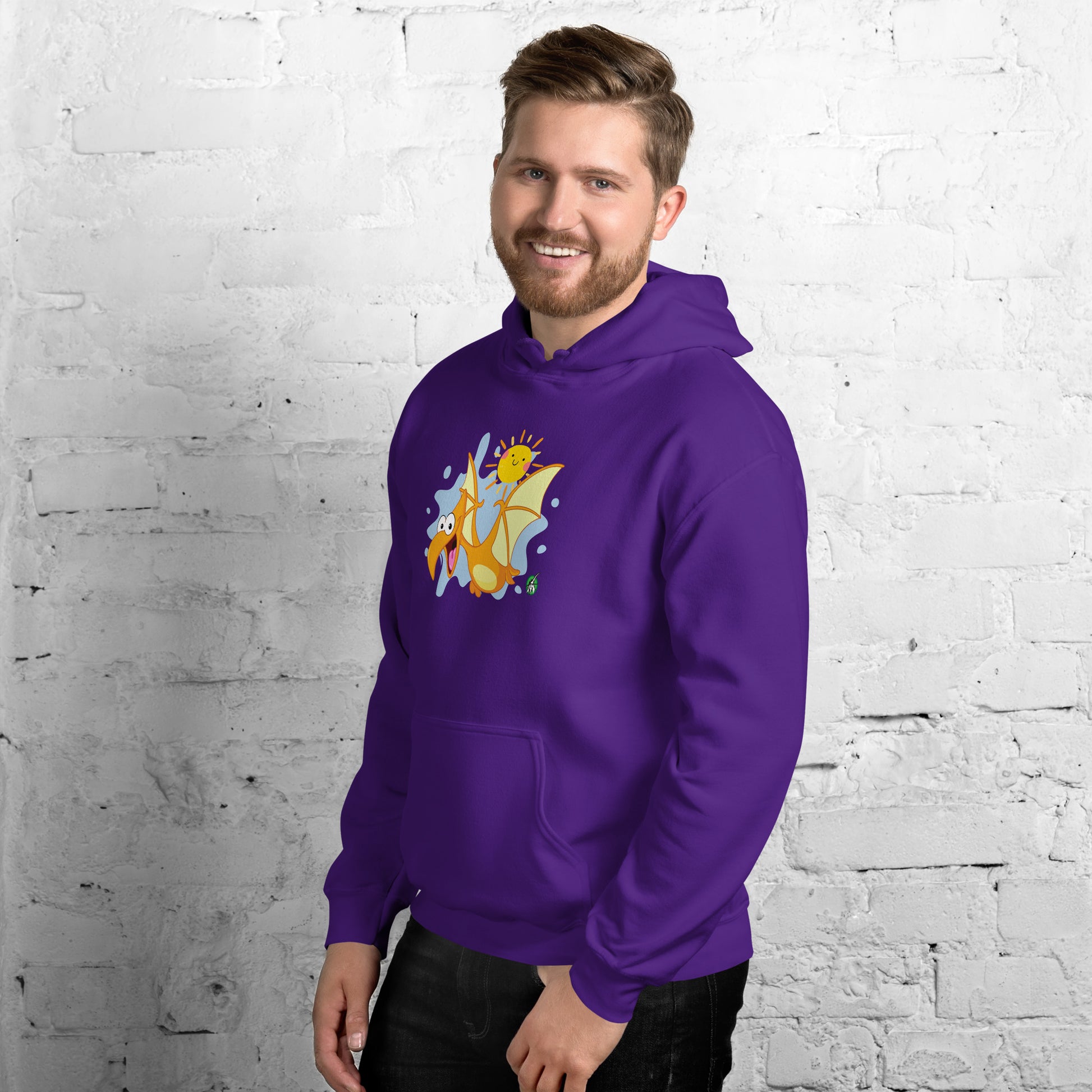 A man standing wearing a purple hoodie with a printed graphic of a smiling cartoon dinosaur and the sun. Designed by Wizard Prints.