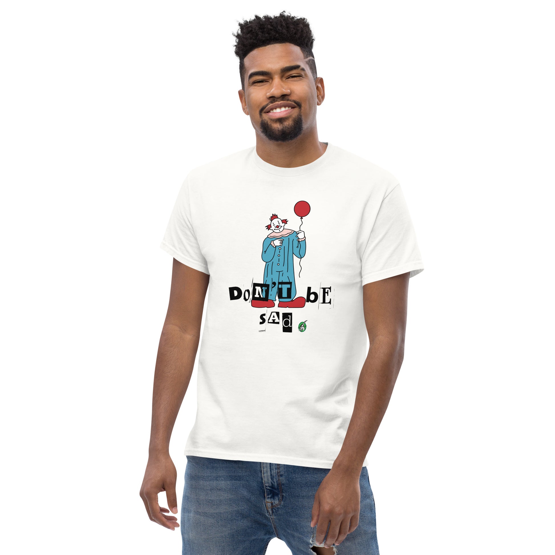 A man standing and wearing a white t-shirt with a printed graphic of a clown holding a balloon with the words, "Don't be sad". Designed by Wizard Prints