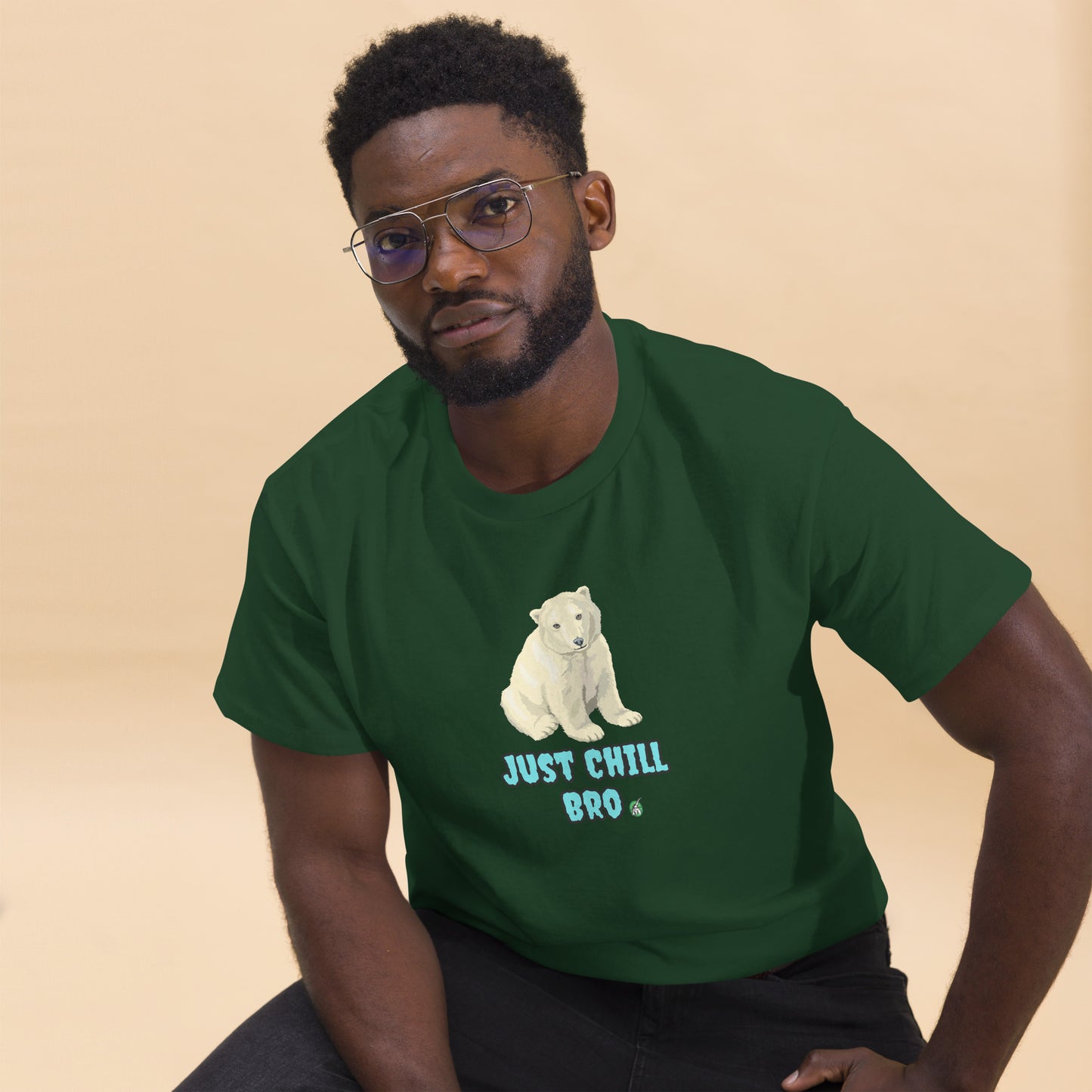 A man sitting and wearing a green t-shirt with a printed graphic of a bear with the words, 'Just Chill Bro'. Designed by Wizard Prints.