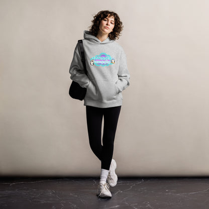 Lady standing wearing a grey hoodie with a graphic print of a couple of pequins in a cloud with the words, snuggly wuggly