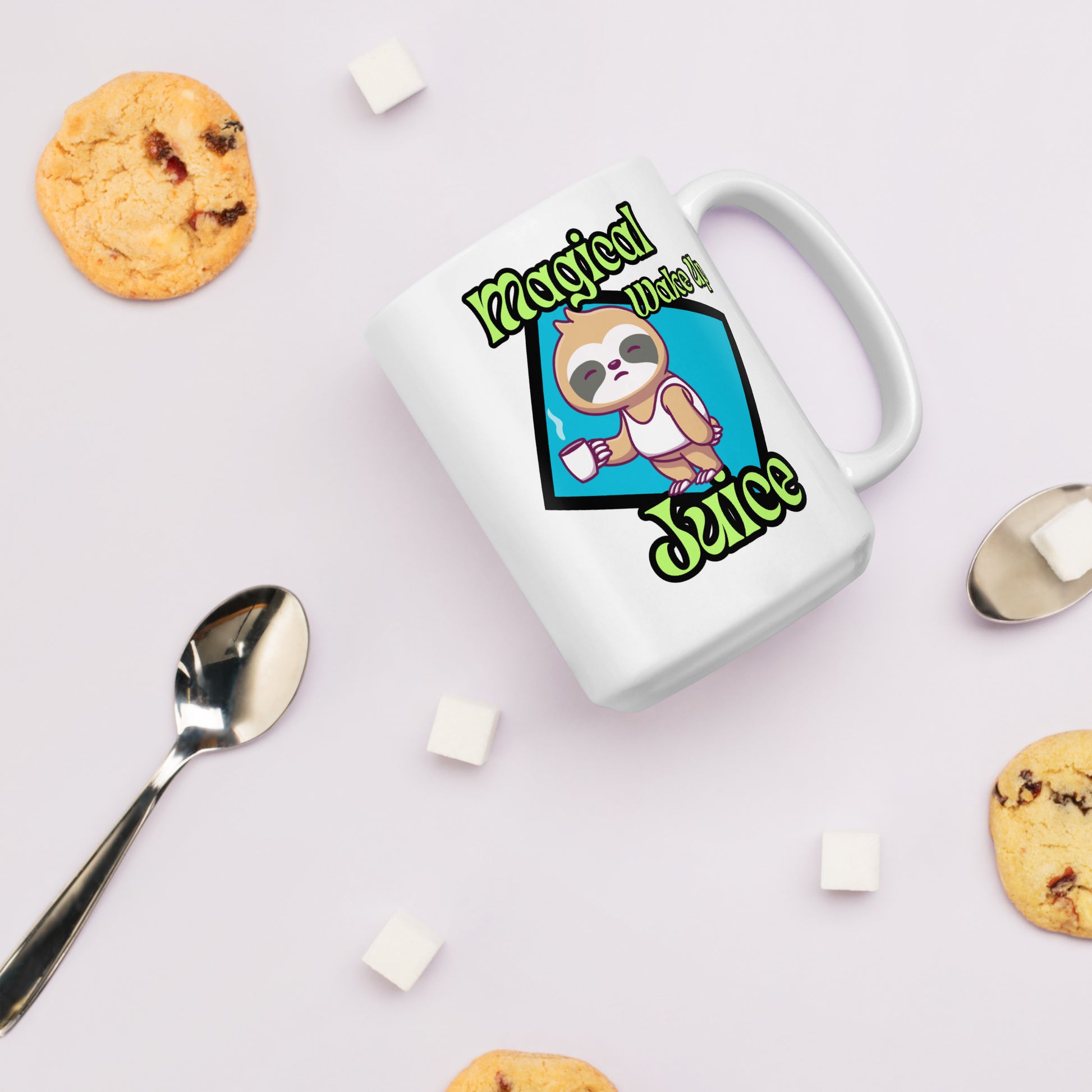 White Wizard Prints mug with a cartoon sloth design and 'Magical Wake up Juice' text on a light surface with cookies and a spoon.
