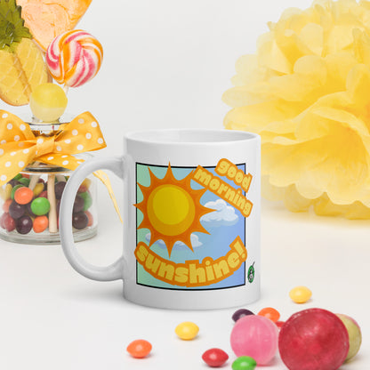 White Wizard Prints mug with 'Good morning sunshine' design and sunny graphic surrounded by colorful candies and flowers on a white background.