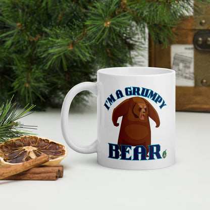 Wizard Prints white mug with grumpy bear graphic and 'I'm a grumpy bear' text on a surface with decorative nature elements.