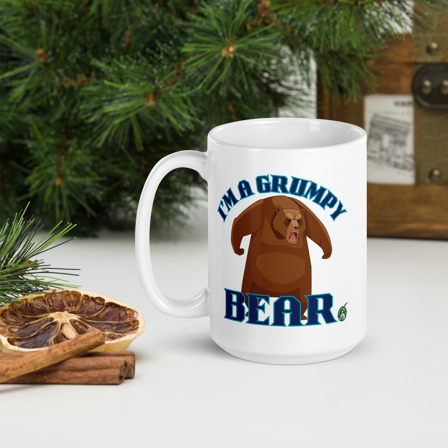 Wizard Prints white mug with grumpy bear graphic and 'I'm a grumpy bear' text on a surface with decorative nature elements.