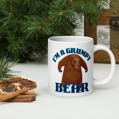 Wizard Prints white mug with grumpy bear graphic and 'I'm a grumpy bear' text on a surface with decorative nature elements.