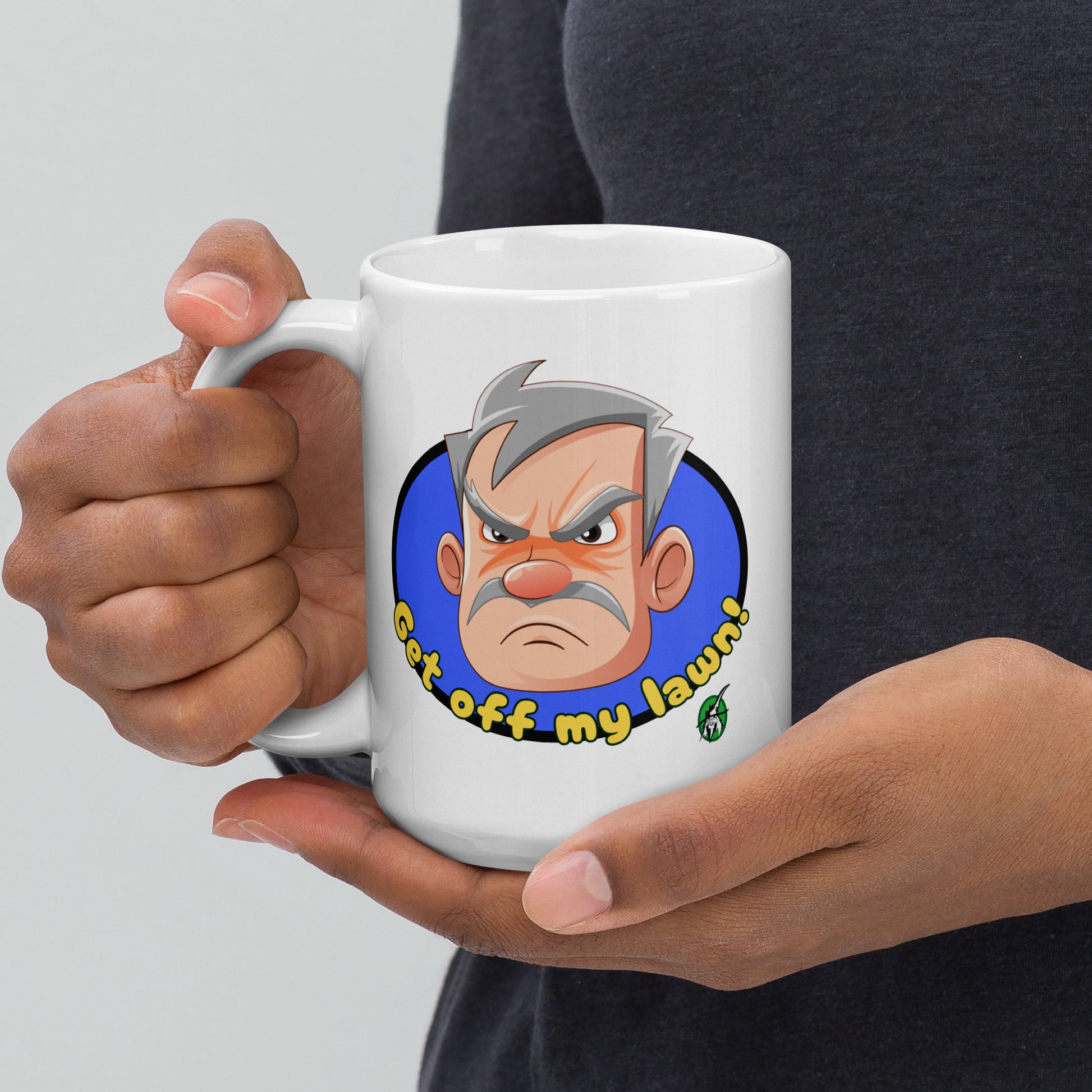 Person holding a white Wizard Prints grumpy old man mug with a cartoon old man graphic and 'Get off my lawn!' text.