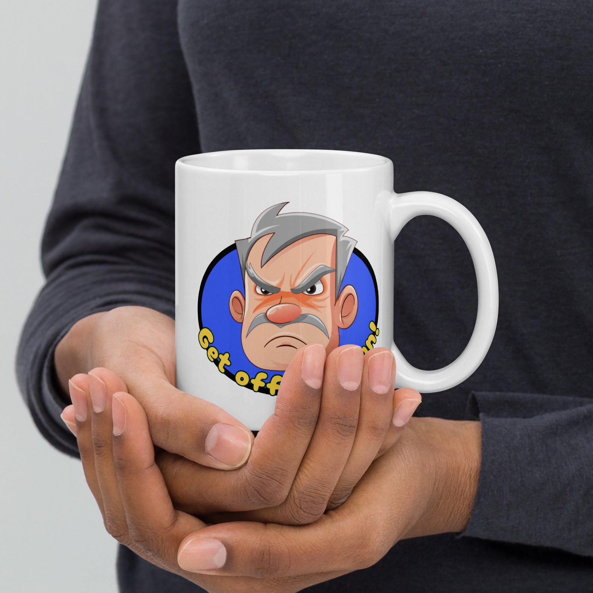Person holding a white Wizard Prints grumpy old man mug with a cartoon old man graphic and 'Get off my lawn!' text.