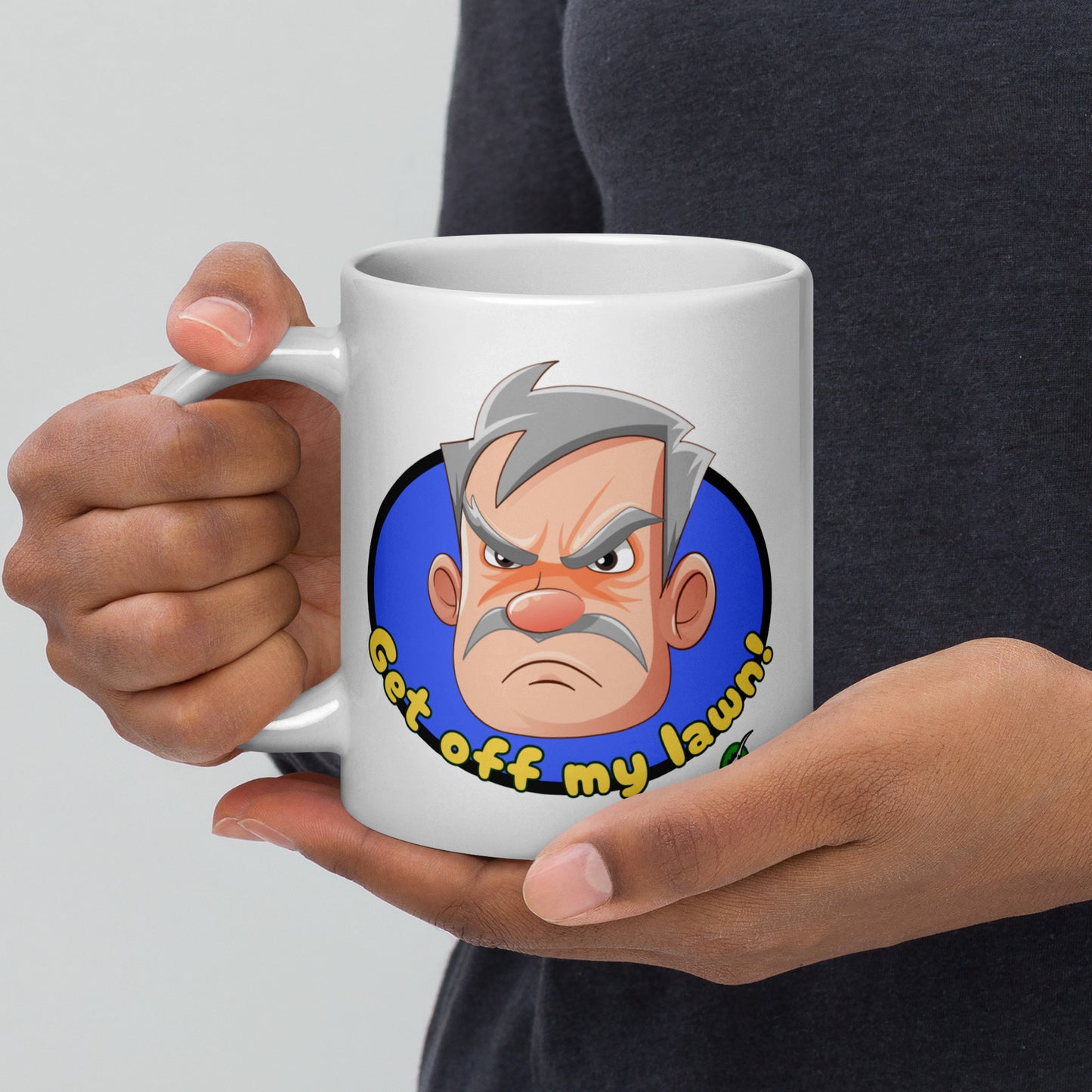 Person holding a white Wizard Prints grumpy old man mug with a cartoon old man graphic and 'Get off my lawn!' text.
