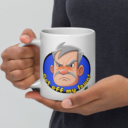Person holding a white Wizard Prints grumpy old man mug with a cartoon old man graphic and 'Get off my lawn!' text.