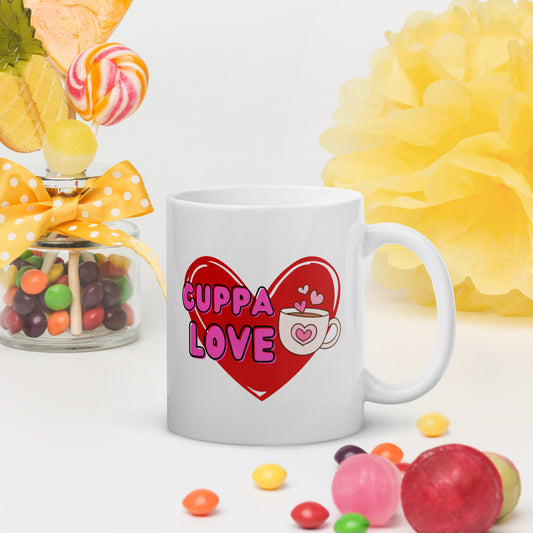 White Wizard Prints mug with a love heart design and 'Cuppa Love' text surrounded by colourful candies and flowers on a white background.
