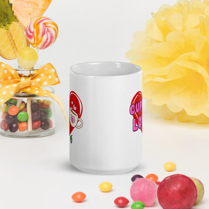 White Wizard Prints mug with a love heart design and 'Cuppa Love' text surrounded by colourful candies and flowers on a white background.