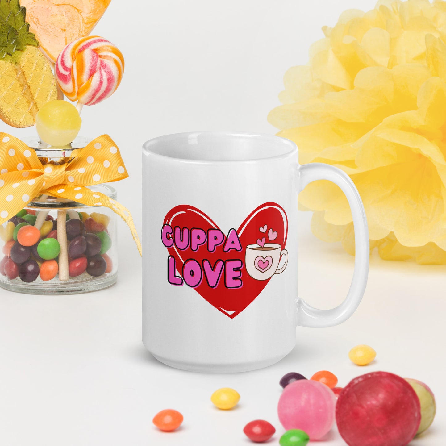 White Wizard Prints mug with a love heart design and 'Cuppa Love' text surrounded by colourful candies and flowers on a white background.