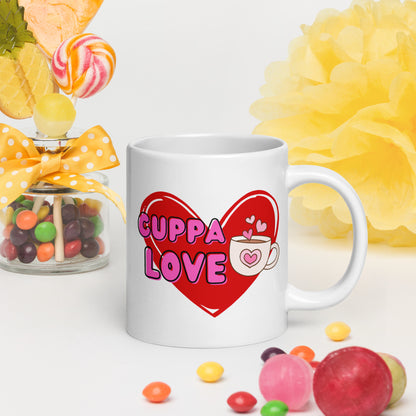 White Wizard Prints mug with a love heart design and 'Cuppa Love' text surrounded by colourful candies and flowers on a white background.