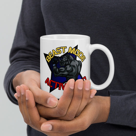 Person holding a Wizard Prints white mug with a graphic design of a rhino and  'Beast Mode Activated' text.