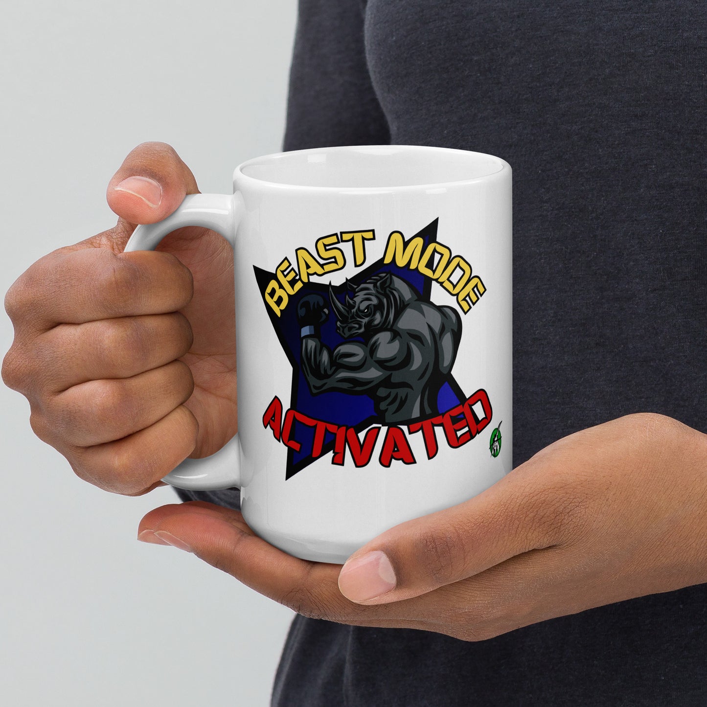 Person holding a Wizard Prints white mug with a graphic design of a rhino and  'Beast Mode Activated' text.