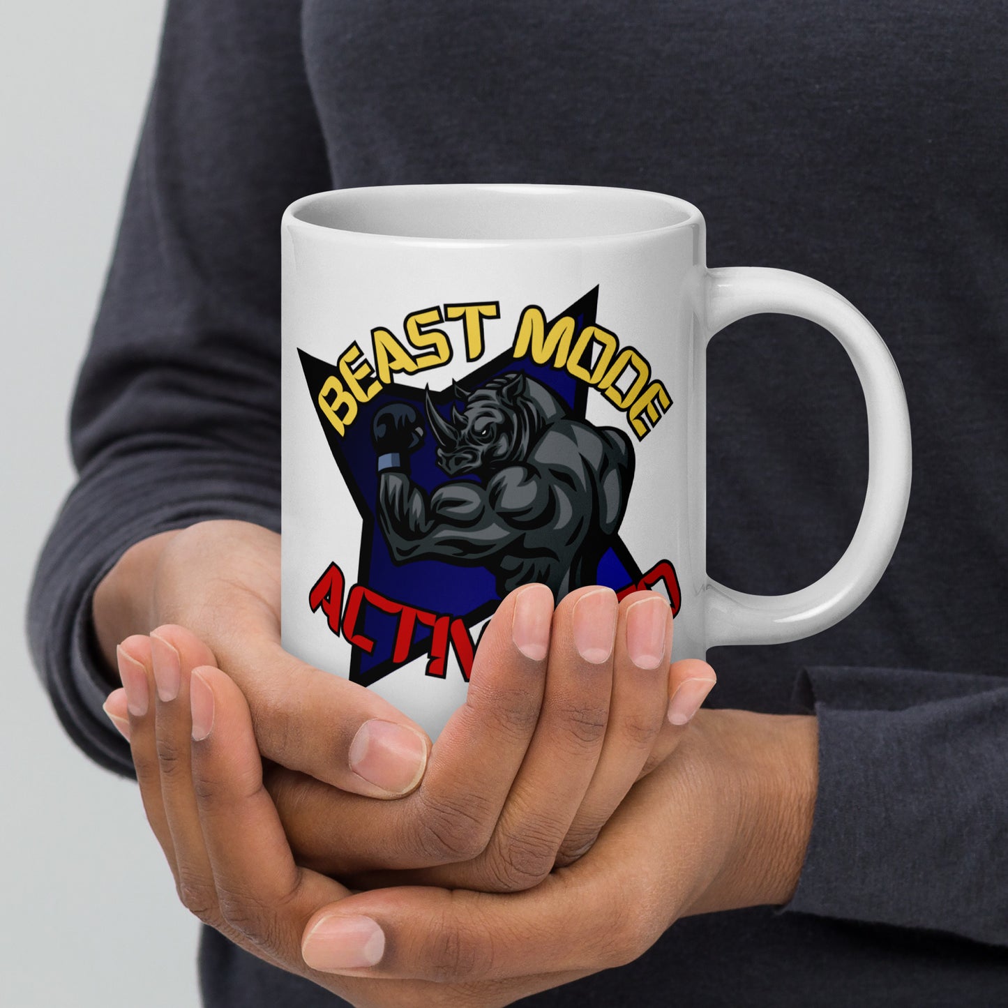 Person holding a Wizard Prints white mug with a graphic design of a rhino and  'Beast Mode Activated' text.