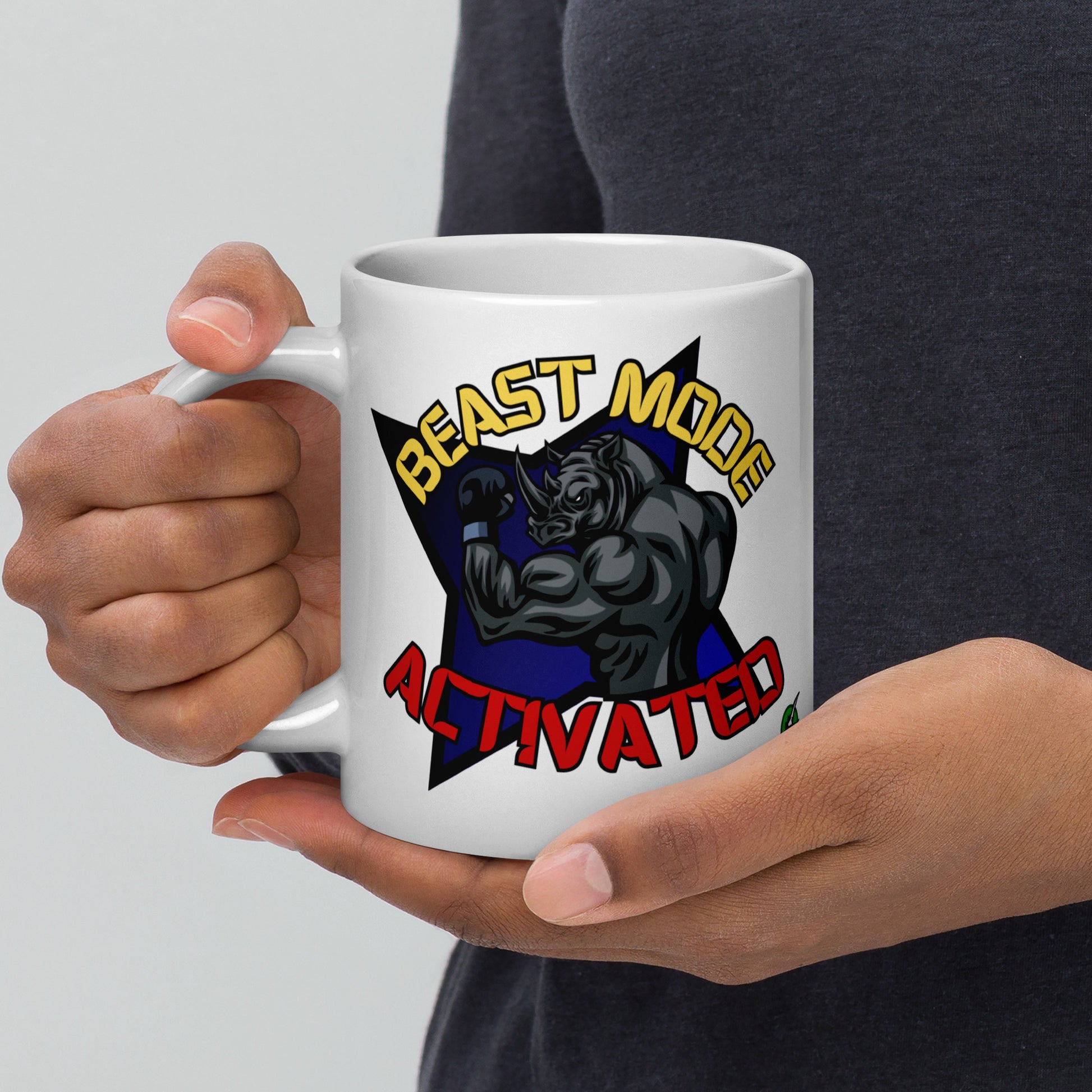 Person holding a Wizard Prints white mug with a graphic design of a rhino and  'Beast Mode Activated' text.