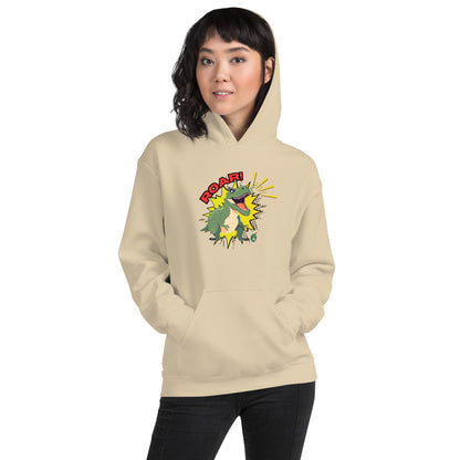 A woman standing wearing a beige hoodie with a printed graphic of a green roaring cartoon dinosaur and the word Roar! Designed by Wizard Prints