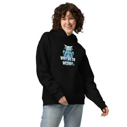 A woman standing wearing a black hoodie by Wizard Prints featuring a printed graphic of a blue ghost girl with the words, Why Be So Weird?.