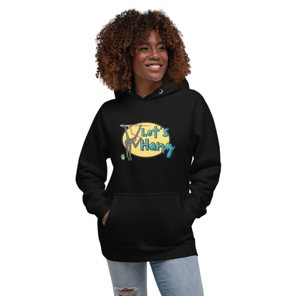 A woman standing wearing black hoodie with a printed graphic of a monkey hanging on a branch with the words, Let's Hang. Designed by Wizard Prints.
