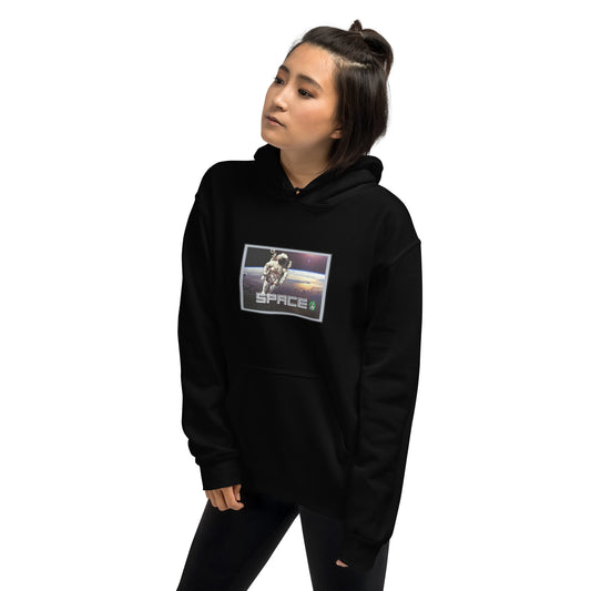 A woman standing wearing a black hoodie with the printed graphic of a real astronaut in space and the word, Space, by Wizard Prints.