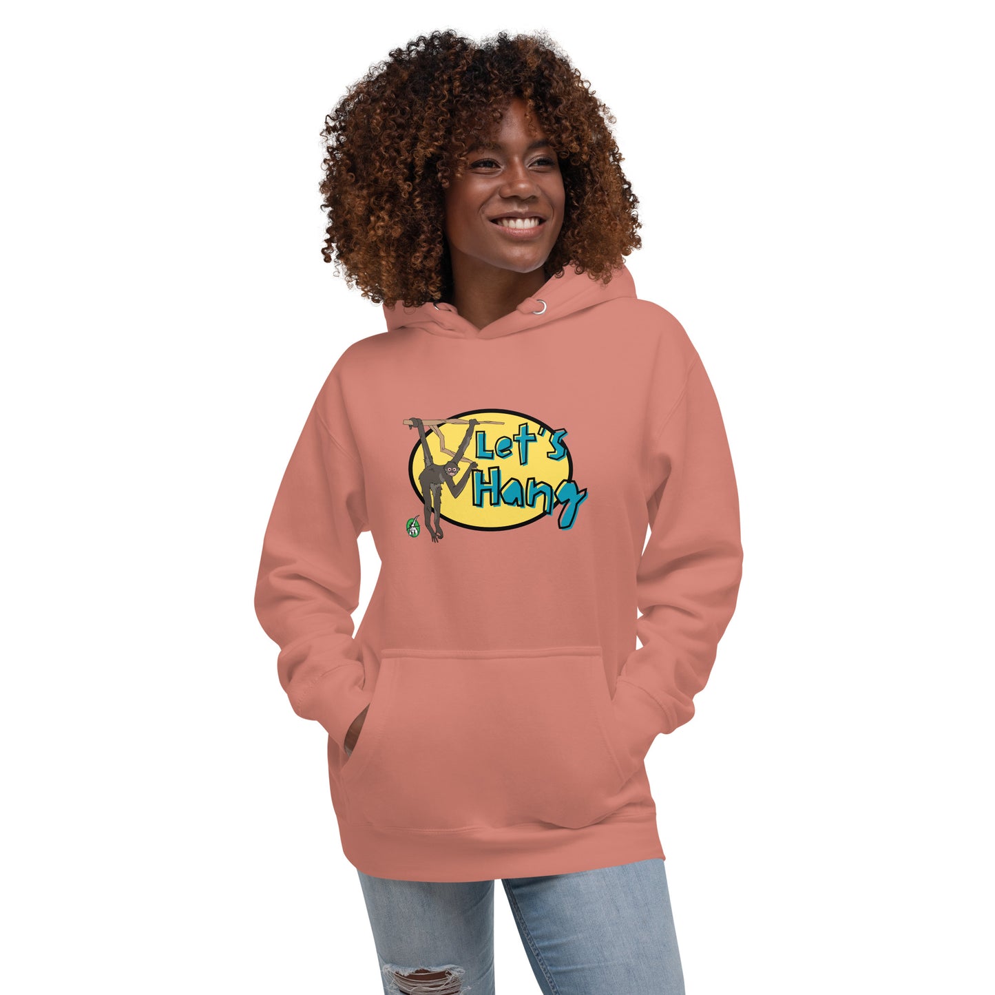 A woman standing wearing a dusty rose hoodie with a printed graphic of a monkey hanging on a branch with the words, Let's Hang. Designed by Wizard Prints.