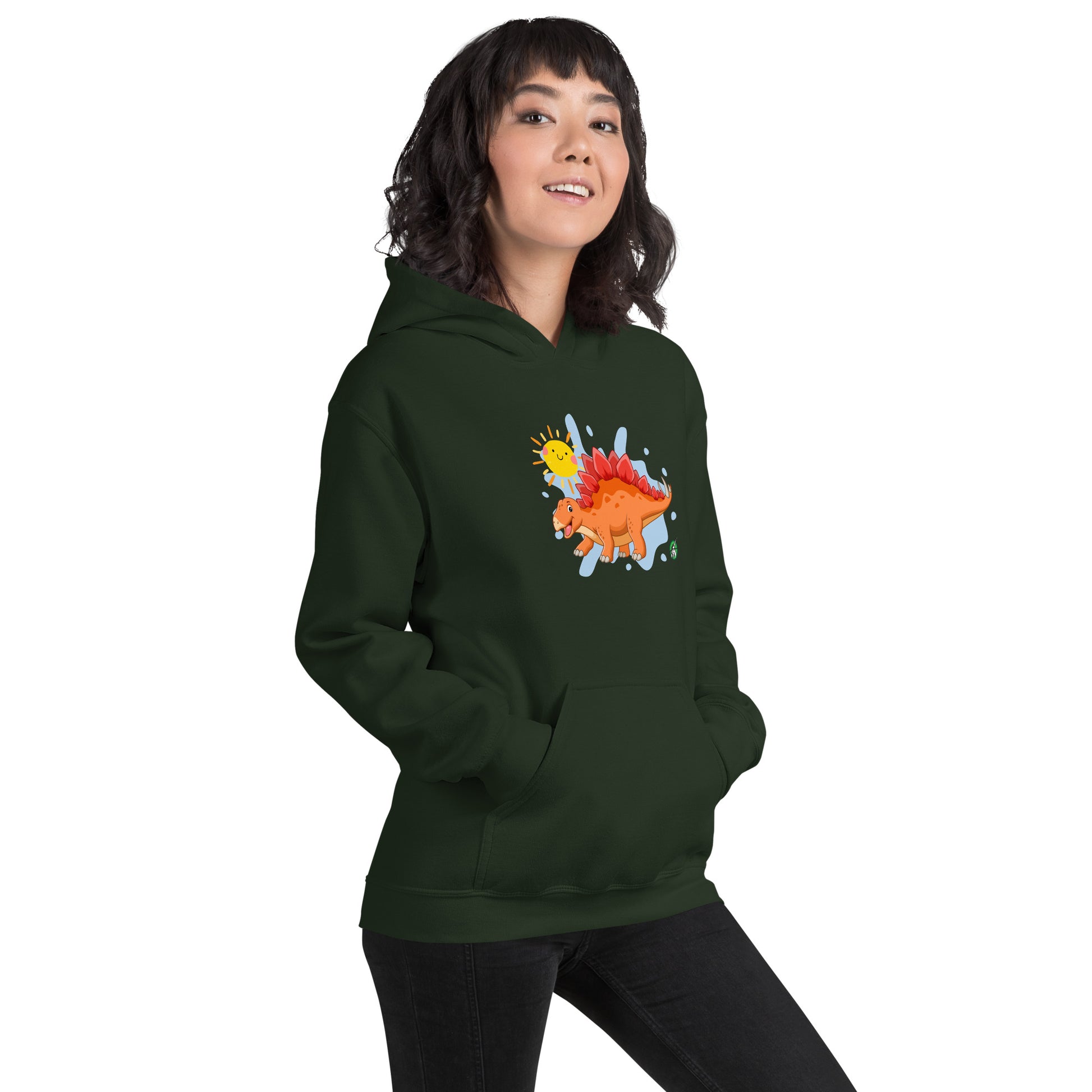 A woman standing wearing a forest green hoodie with the printed graphic of an orange cartoon dinosaur and the sun, by Wizard Prints.
