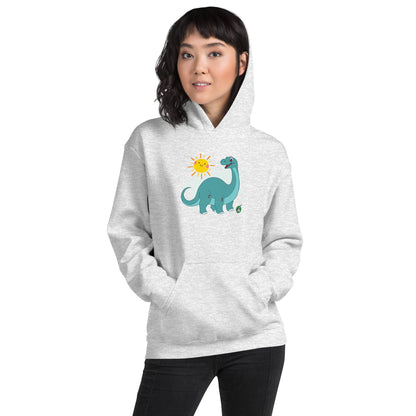 A woman standing wearing an ash hoodie with a printed graphic of a smiling cartoon dinosaur and the sun. Designed by Wizard Prints.