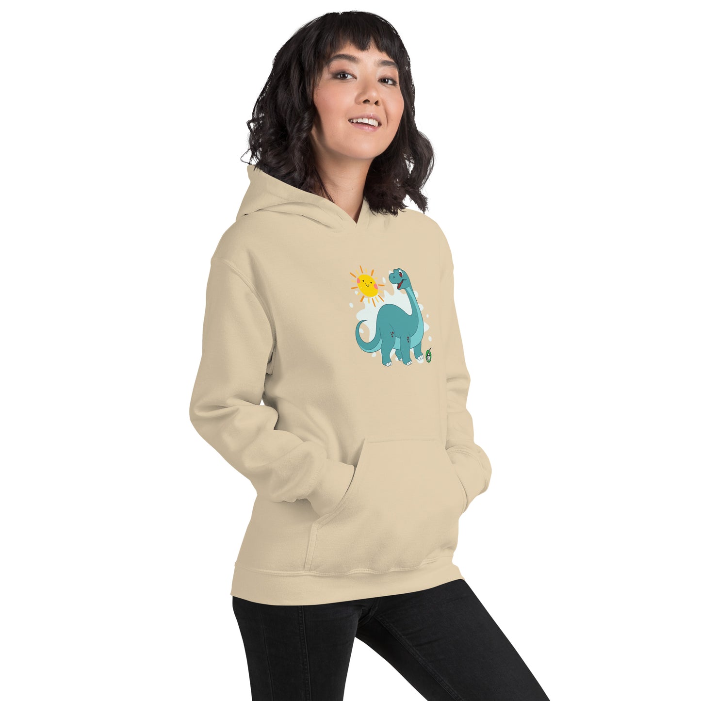 A woman standing wearing a beige hoodie with a printed graphic of a smiling cartoon dinosaur and the sun. Designed by Wizard Prints.