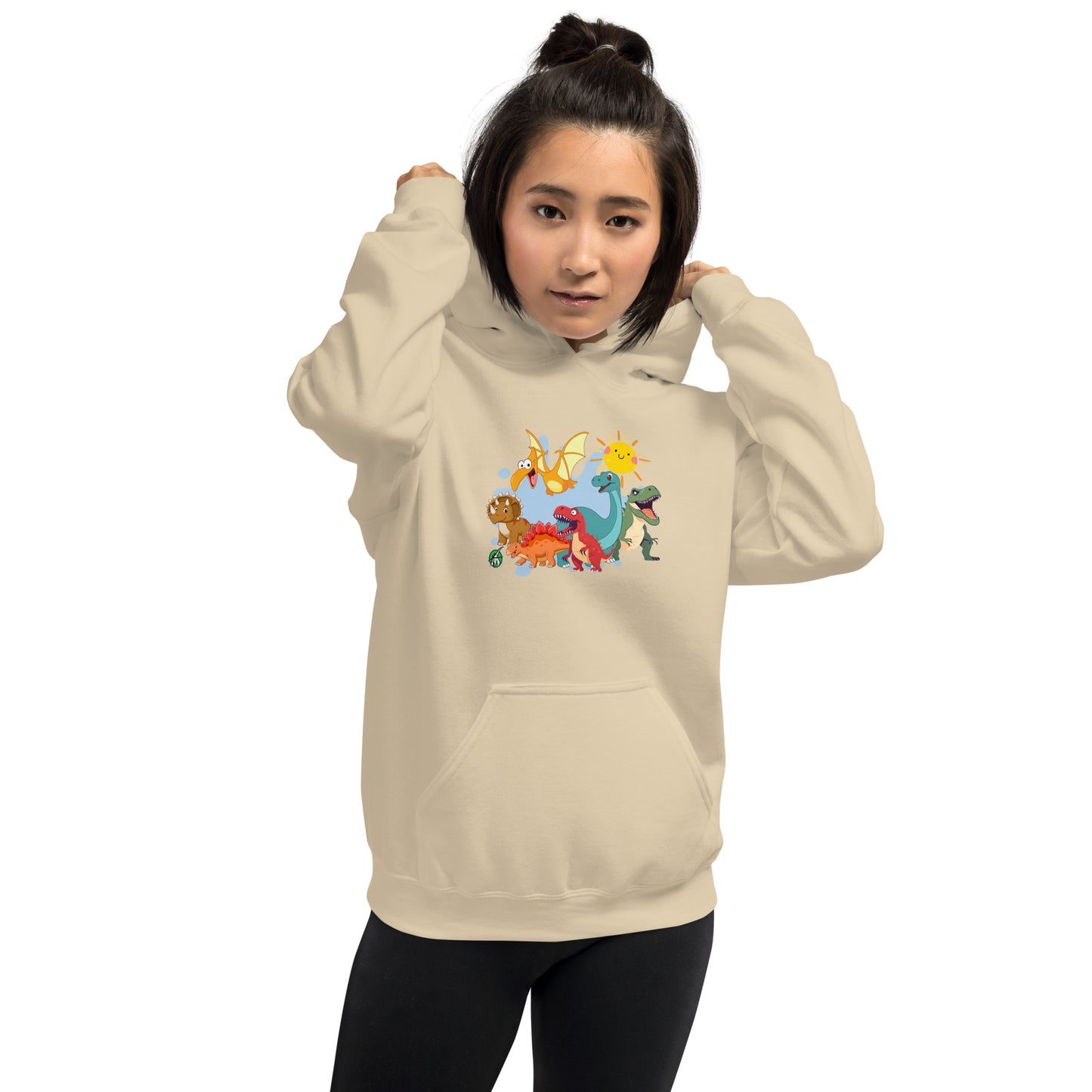 A woman standing wearing a beige hoodie with a printed graphic of different colorful dinosaur types and the sun. Designed by Wizard Prints.