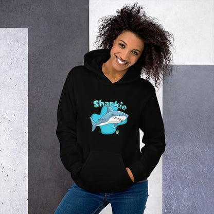 A woman standing wearing a black hoodie with a printed graphic of a cartoon shark and the word, Sharkie. Designed by Wizard Prints.