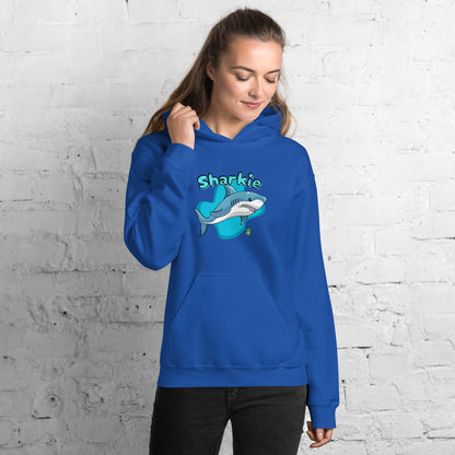 A woman standing wearing a blue hoodie with a printed graphic of a cartoon shark and the word, Sharkie. Designed by Wizard Prints.