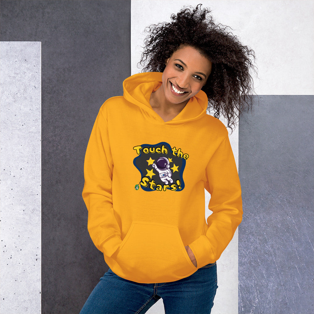 A woman standing wearing a gold hoodie with a printed graphic of a cartoon astronaut and the words, Touch the Stars. Designed by Wizard Prints.