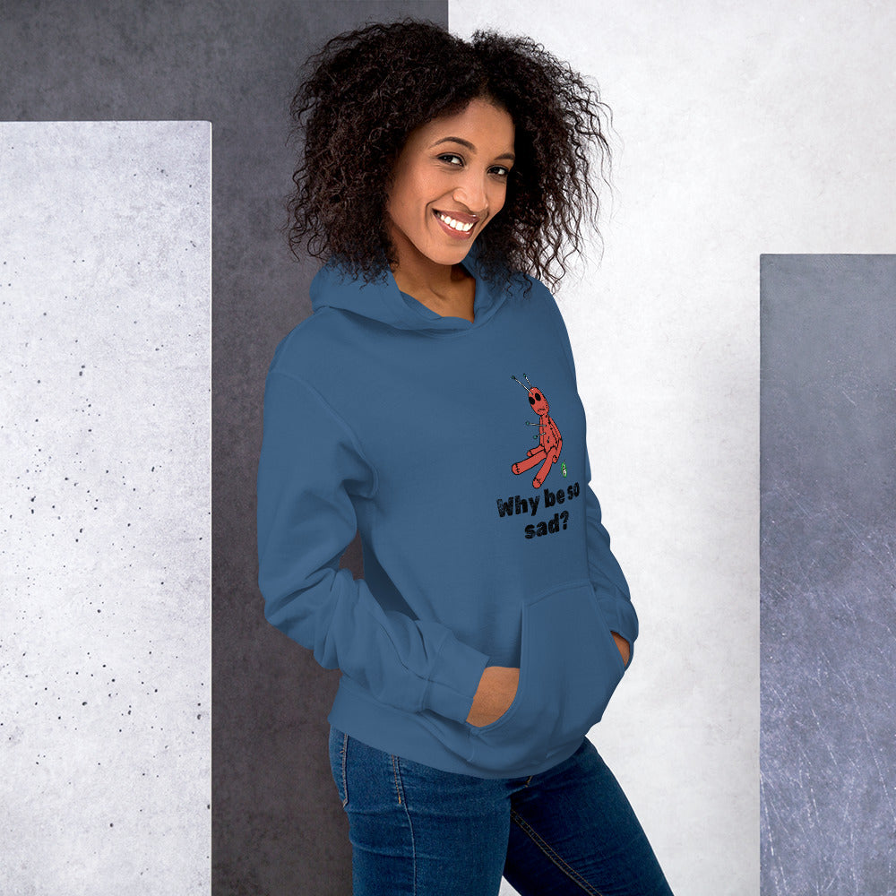 A woman standing wearing an indigo blue hoodie with a printed graphic of a voodoo doll and the words, Why be so sad? Designed by Wizard Prints.