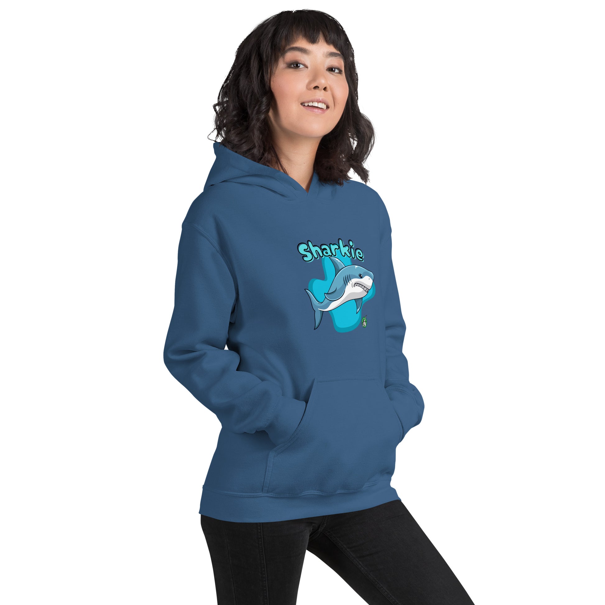 A woman standing wearing an indigo hoodie with a printed graphic of a cartoon shark and the word, Sharkie. Designed by Wizard Prints.